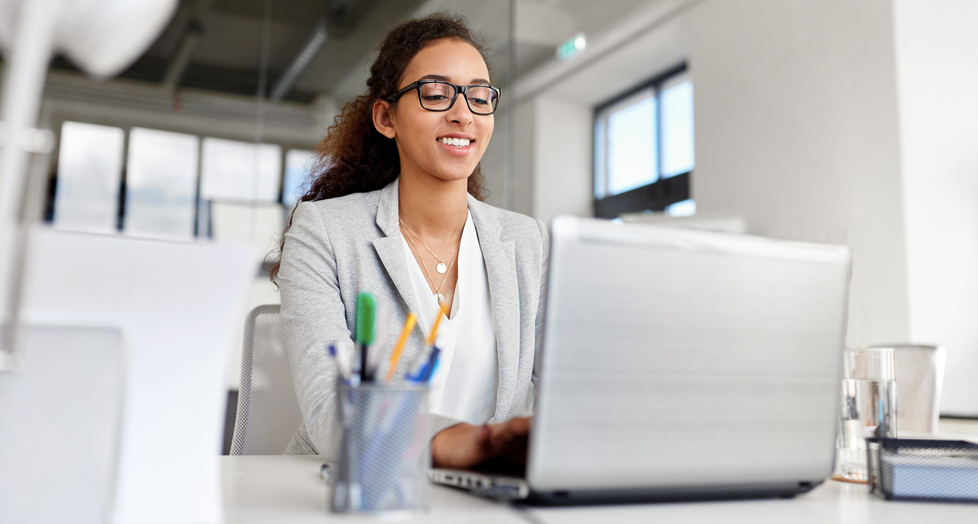 person wearing glasses and using laptop in office